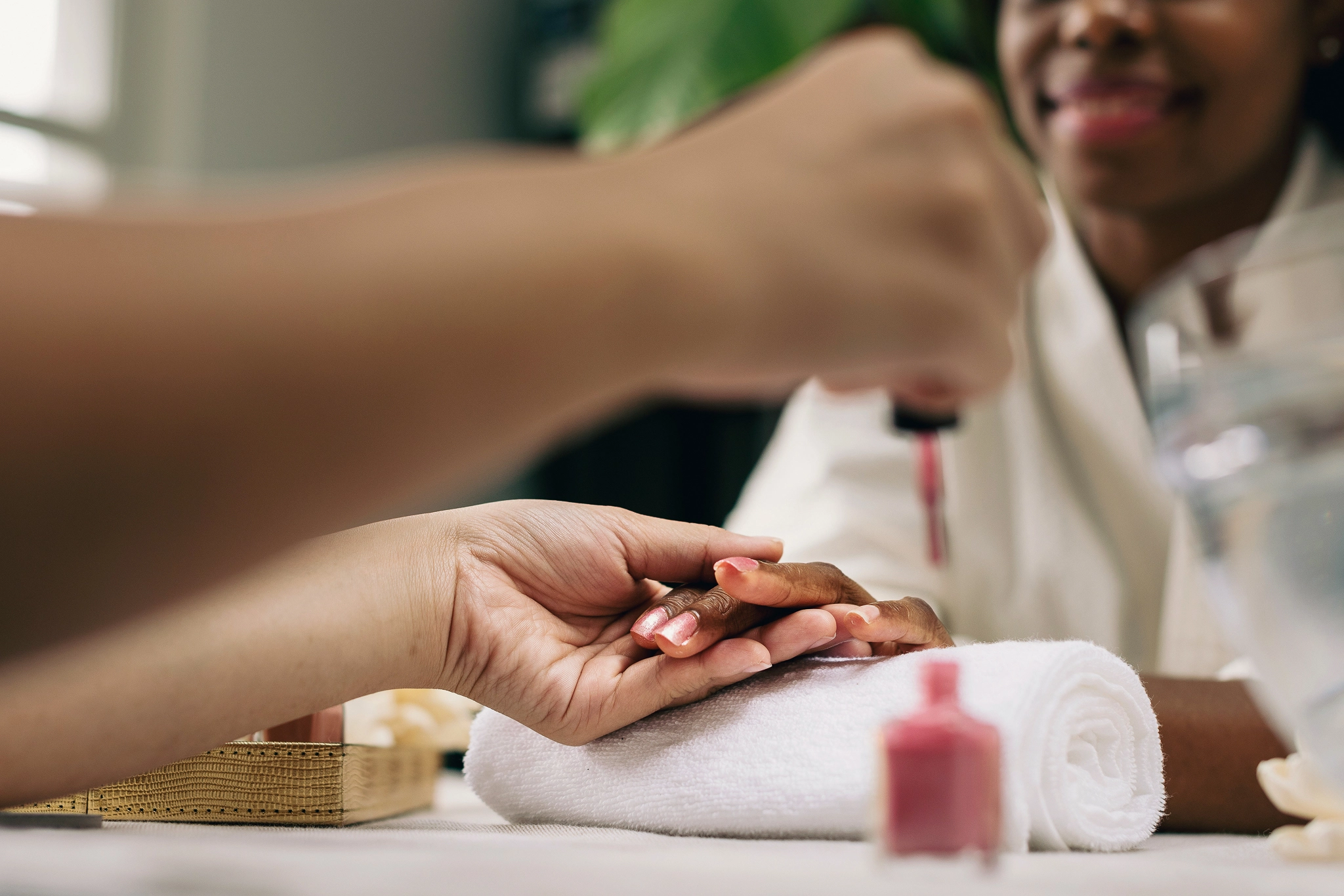 A nail technician prepares to apply polish to a client's nails